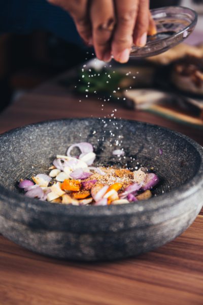 close-up of spices being added to a bowl during cooking