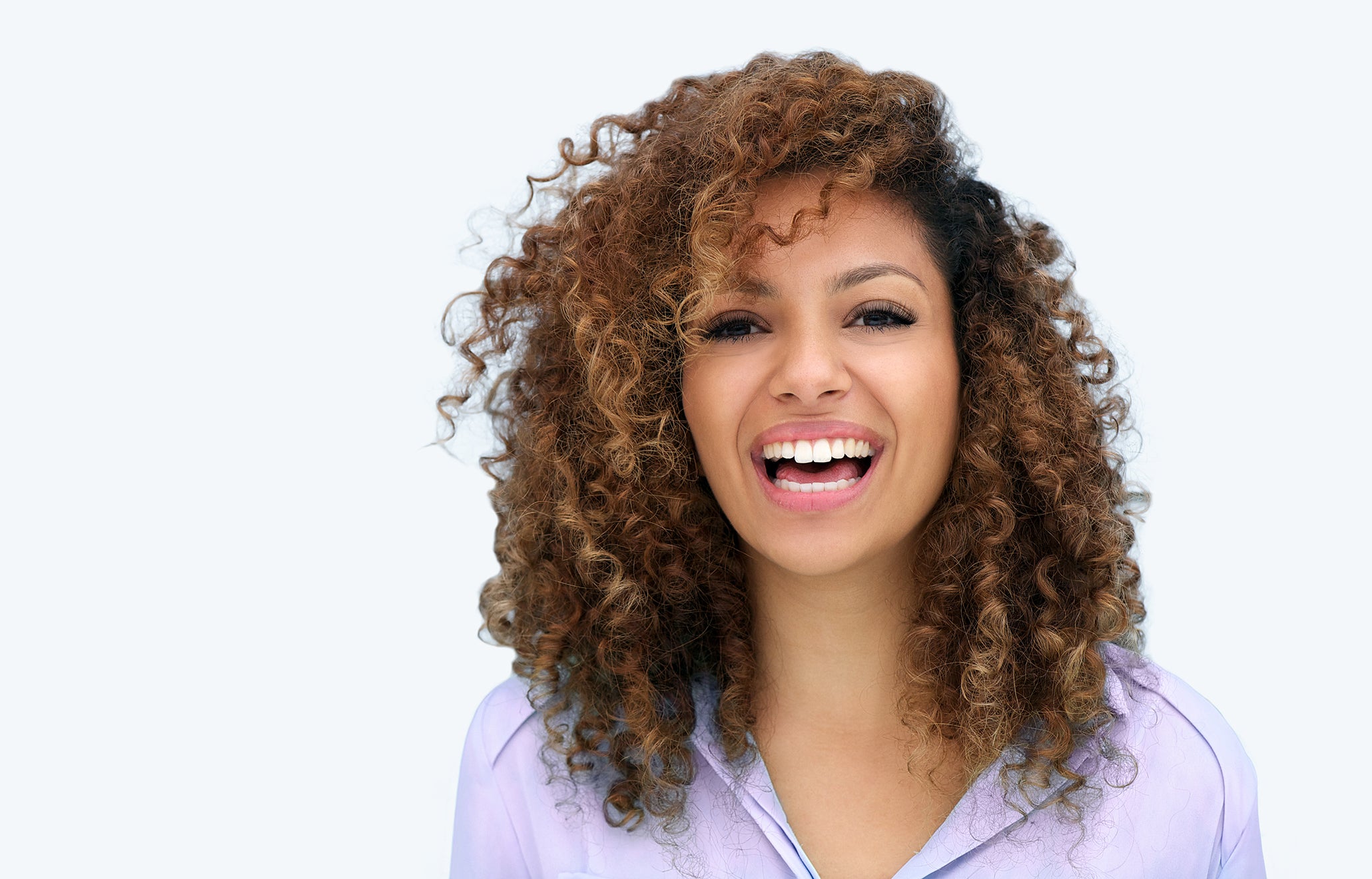 Mid-shot of happy black woman with curly hair and custom lashes and brows