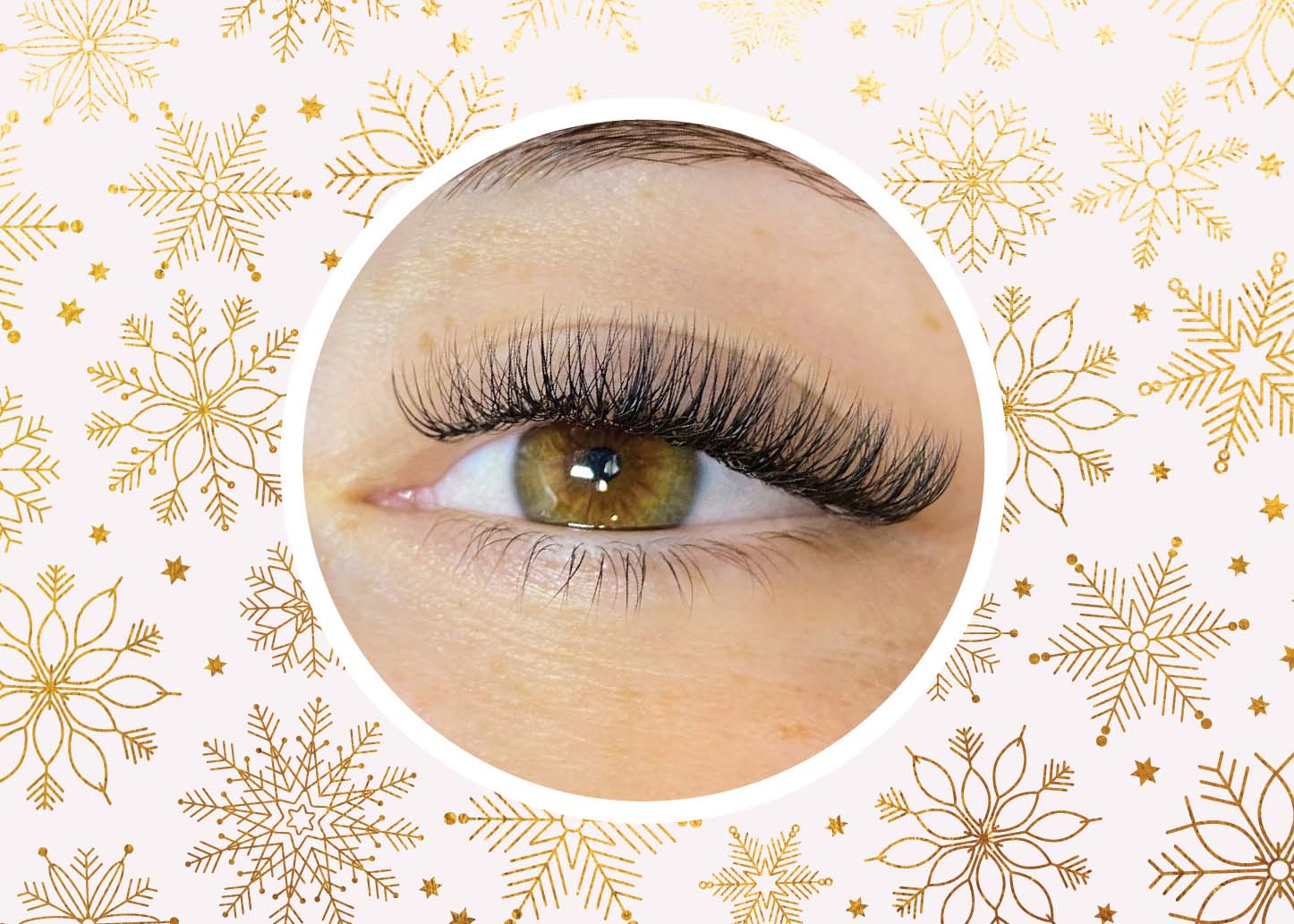 Eye with lash extensions from The Lash Lounge on a wintry background that resembles holiday wrapping paper