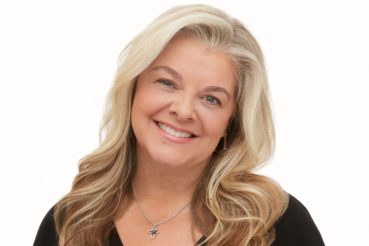 mid-shot of a woman smiling with tinted eyebrows