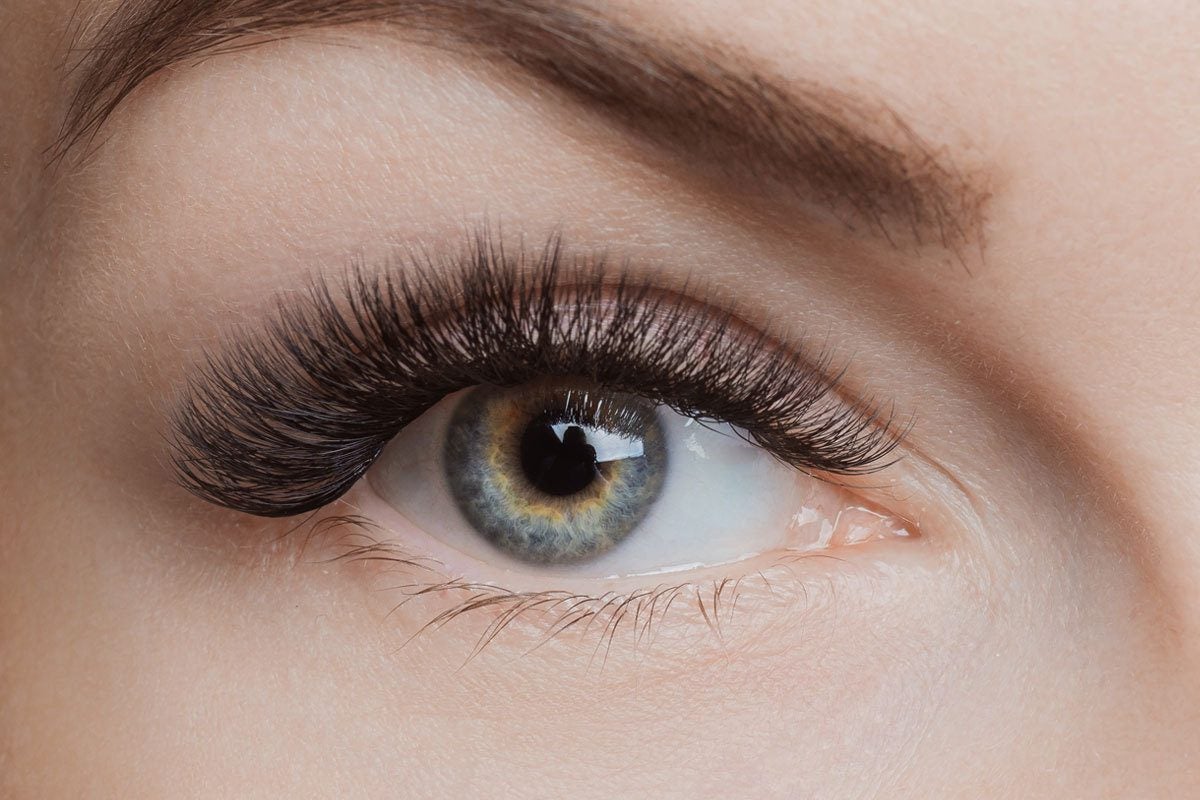 A close-up of a woman's eye and eyelash extensions