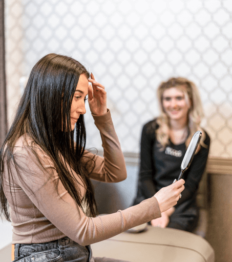 A Lash Lounge guest admiring her lash extensions after her member-only discounted refill.