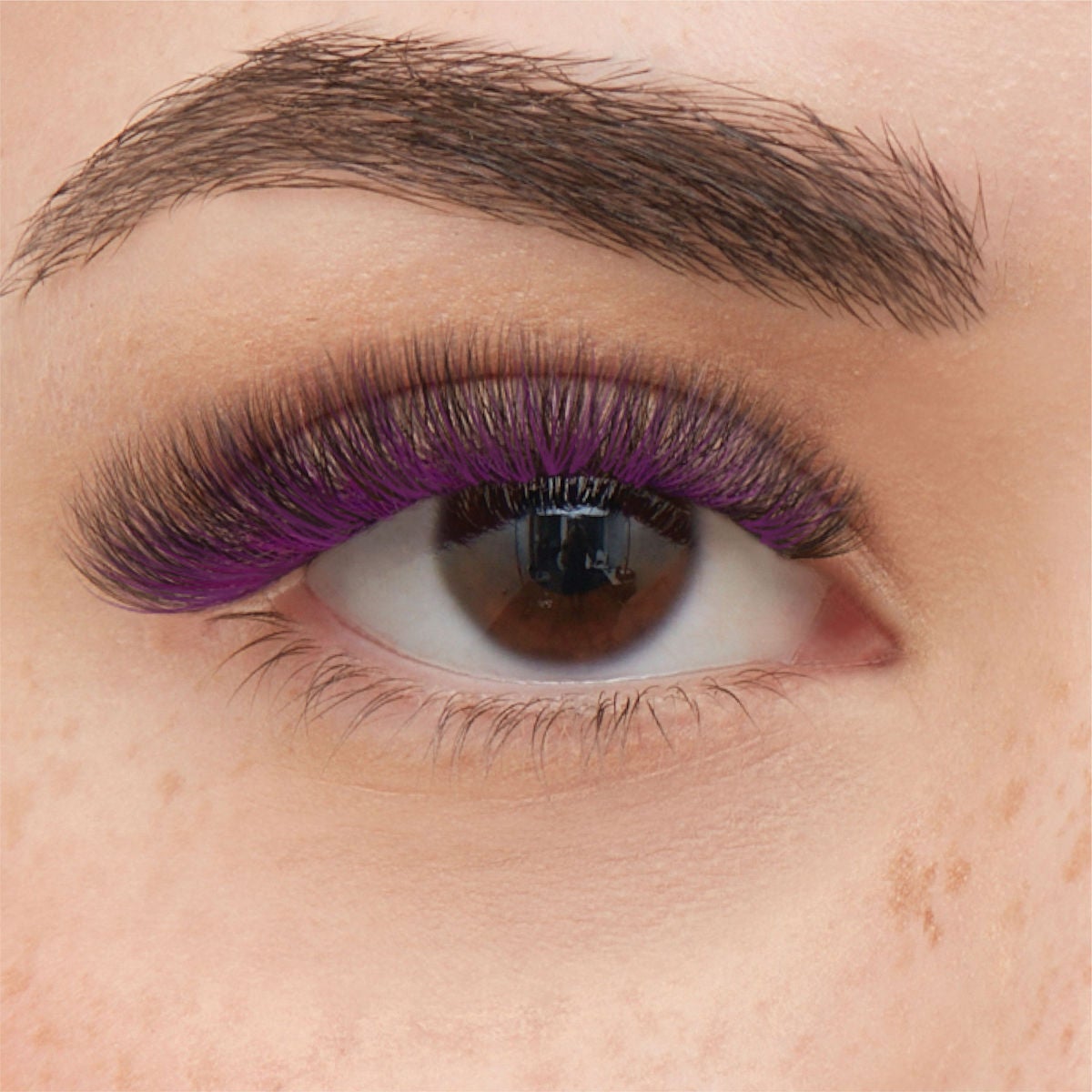 close-up of woman's eye with purple lashes