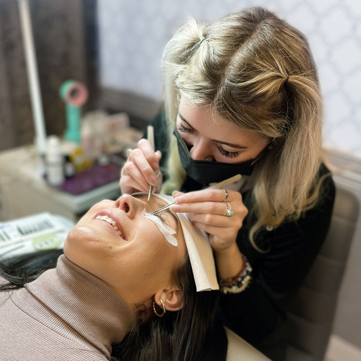 woman lying down getting lash extensions